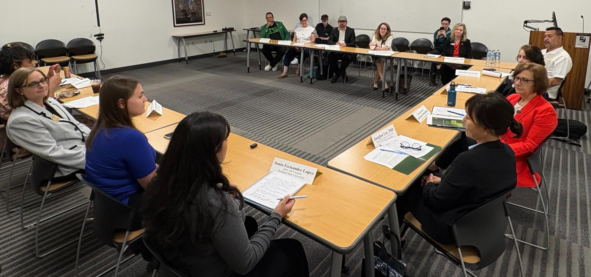 Rep Bonamici, Students, Educators sit at a U-shaped table in a conference room