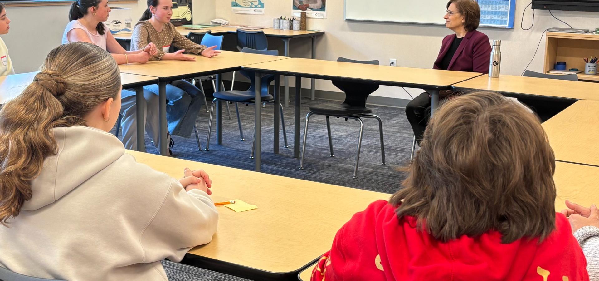 Rep Bonamici talks to student roundtable in a classroom